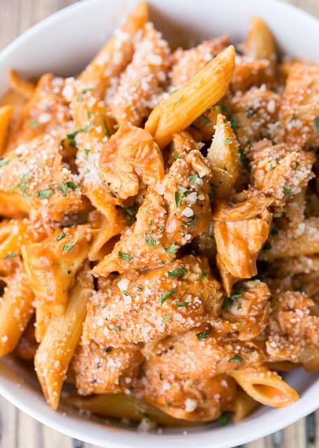 Buffalo Chicken Pasta - ready in under 20 minutes! SO simple and SO delicious! Great weeknight pasta recipe! Chicken and penne pasta tossed in tomato sauce, wing sauce, shallots, garlic, worcestershire and heavy cream. Top with some grated Parmesan cheese. Everyone cleaned their plates!