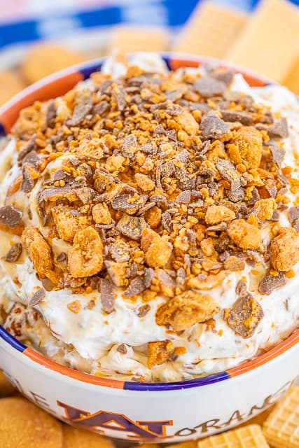 Butterfinger Dip - only 4 ingredients and ready in minutes!!! This stuff should come with a warning label - SO good!!! Cream cheese, cool whip, brown sugar and butterfinger candy bars. Serve with vanilla wafers, sugar cookies, fruit, graham crackers or pretzels. Can make a day in advance and refrigerate until ready to serve. Great for tailgating and holiday parties!! Everyone RAVES about this yummy dessert dip! #dessert #dip #partyfood #butterfingers