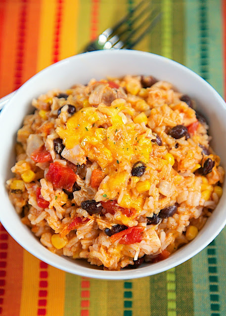 Chicken Enchilada Rice Bake Recipe - chicken, black beans, corn, Rotel tomatoes, cheese, rice and enchilada sauce! SO good! I wanted to eat the whole pan! Use rotisserie chicken and this is ready for the oven in 10 minutes. Super quick Mexican dinner recipe.