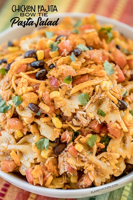 Chicken Fajita Bow Tie Pasta Salad - crazy good!! Chicken and bow tie pasta tossed with lime juice, cumin, chili powder, cilantro, olive oil, corn, tomatoes, black beans, salsa, cheese and Doritos! Can make without the chicken and serve as a side dish. Great for summer potlucks! #pastasalad #mexican #chickenrecipe #easyrecipe #nobakerecipe