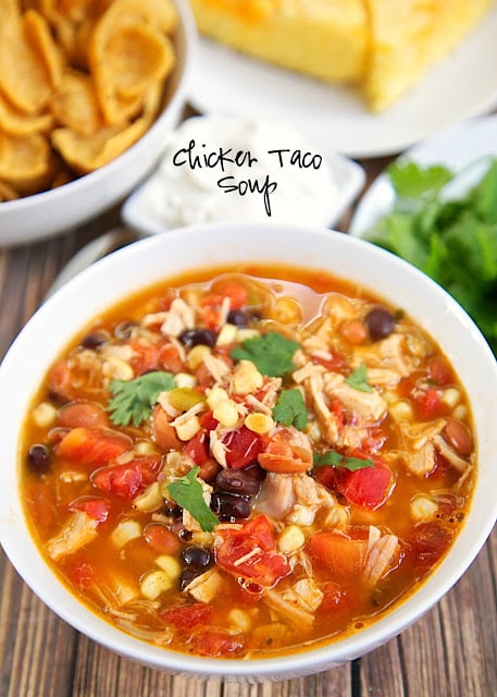 Chicken Taco Soup Recipe - Chicken, beans, corn, tomatoes, Ranch mix and taco seasoning. Can be made two different ways. On the stovetop with some rotisserie chicken or in the slow cooker with some boneless chicken breasts. Either way, it is super delicious and packed FULL of flavor! Serve with some cornbread for a delicious meal!