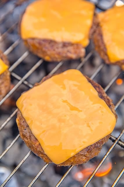 Cola Burgers - seriously delicious!! Ground beef, coke, French dressing, saltine crackers, and parmesan cheese. Top with your favorite cheese!! Can make patties ahead of time and freeze for later. Great for all your cookouts and tailgates! YUM! #burgers #grilling #tailgating #cookout