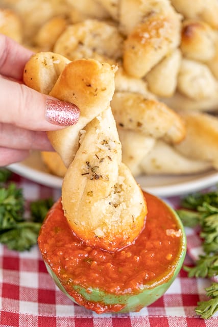 dipping a parmesan bread stick into pizza sauce