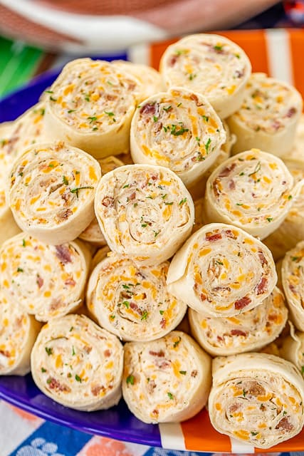 Crack Chicken Pinwheels - I am OBSESSED with these sandwiches! Cream cheese, cheddar, bacon, ranch and chicken wrapped in a tortilla. So simple to make with rotisserie chicken and precooked bacon. Can make ahead of time and refrigerate until ready to eat. Perfect for parties and tailgating!! #pinwheels #chicken #tailgating #bacon #sandwich #partyfood