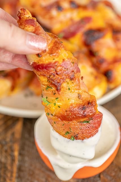 Crack Chicken Tenders - CRAZY good!! Chicken tenders seasoned with ranch, topped with cheese and wrapped in bacon. SO easy and SOOO delicious!!! Great for a quick lunch or dinner or tailgating! Dip in additional ranch dressing. I always have to double the recipe! This easy chicken recipe doesn't last long! #chicken #bacon #cheese #chickenrecipe #bakedchicken