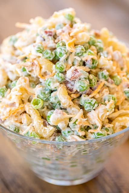 Cracked Out Pea Salad - Macaroni and green peas tossed in mayonnaise, cheddar, bacon and ranch. Seriously delicious!!! Great for potlucks or a side dish with a sandwiches. Great for all your spring and summer cookouts! Can make ahead and refrigerate until ready to serve. It has become our favorite pasta salad recipe!! #pastasalad #sidedish #bacon #ranch