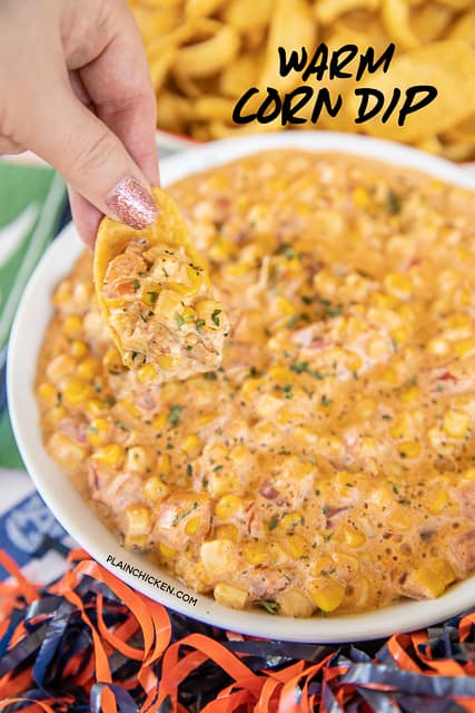 dipping chip into bowl of corn dip
