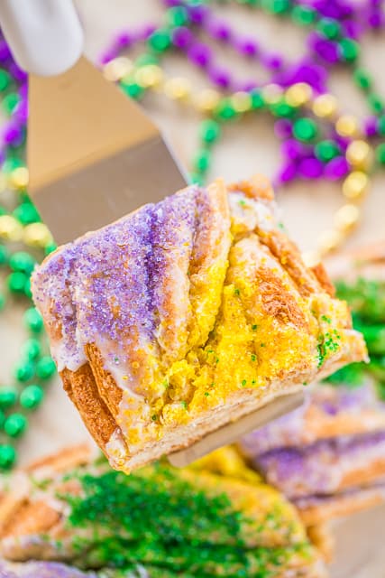 Easy King Cake Braid - perfect for Mardi Gras!!! Easy King Cake made with refrigerated french bread dough - stuffed with cream cheese, cinnamon and sugar. Topped with a quick powdered sugar and milk glaze and sprinkled with yellow, purple and green sugar. SO festive!!! Ready to eat in 30 minutes! Great for breakfast or dessert. I took this to a party and it was gone in a flash!!! YUM! #kingcake #mardigras 