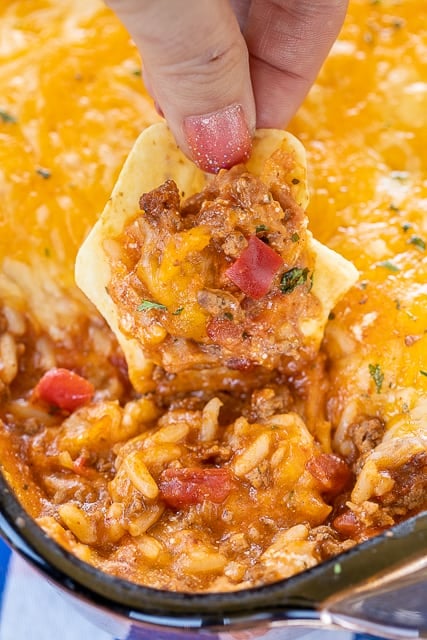 Enchilada Dipping Rice - seriously delicious!! Serve as a dip with chips or as a main dish. Everyone LOVES this yummy Mexican casserole!!! Ground beef, taco seasoning, enchilada sauce, cheese soup, refried beans, rice and cheese. Can make in advance and refrigerate until ready to bake. We make this at least once a month! SO good!!! #mexican #casserole #dip