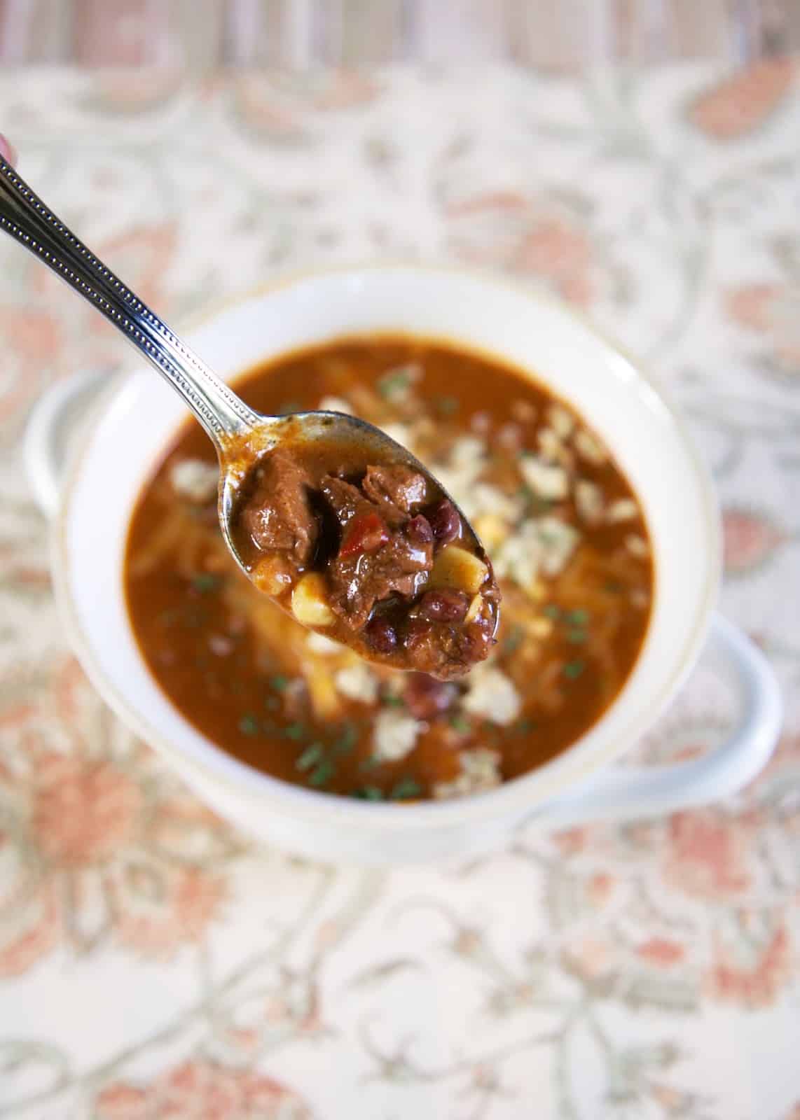 Beef Enchilada Soup made in the crock pot - so easy and tastes amazing! Stew meat, enchilada sauce, cheese soup, black beans, corn, beef broth, oregano and cheddar cheese. Throw everything in the slow cooker and dinner is done! Serve with some cornbread for an easy weeknight dinner. Can freeze and cook when ready. #soup #beef #slowcooker #crockpot #mexican #freezermeal