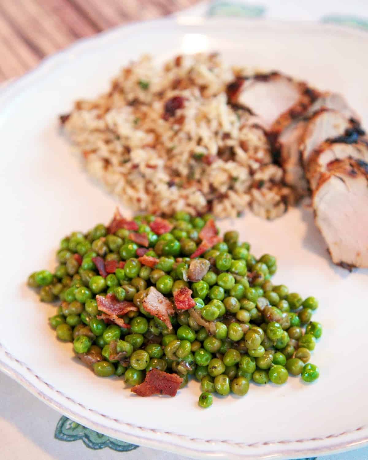Green Peas with Crispy Bacon - jazz up frozen peas with orange juice, shallots and bacon. SO yummy! Ready in under 10 minutes!