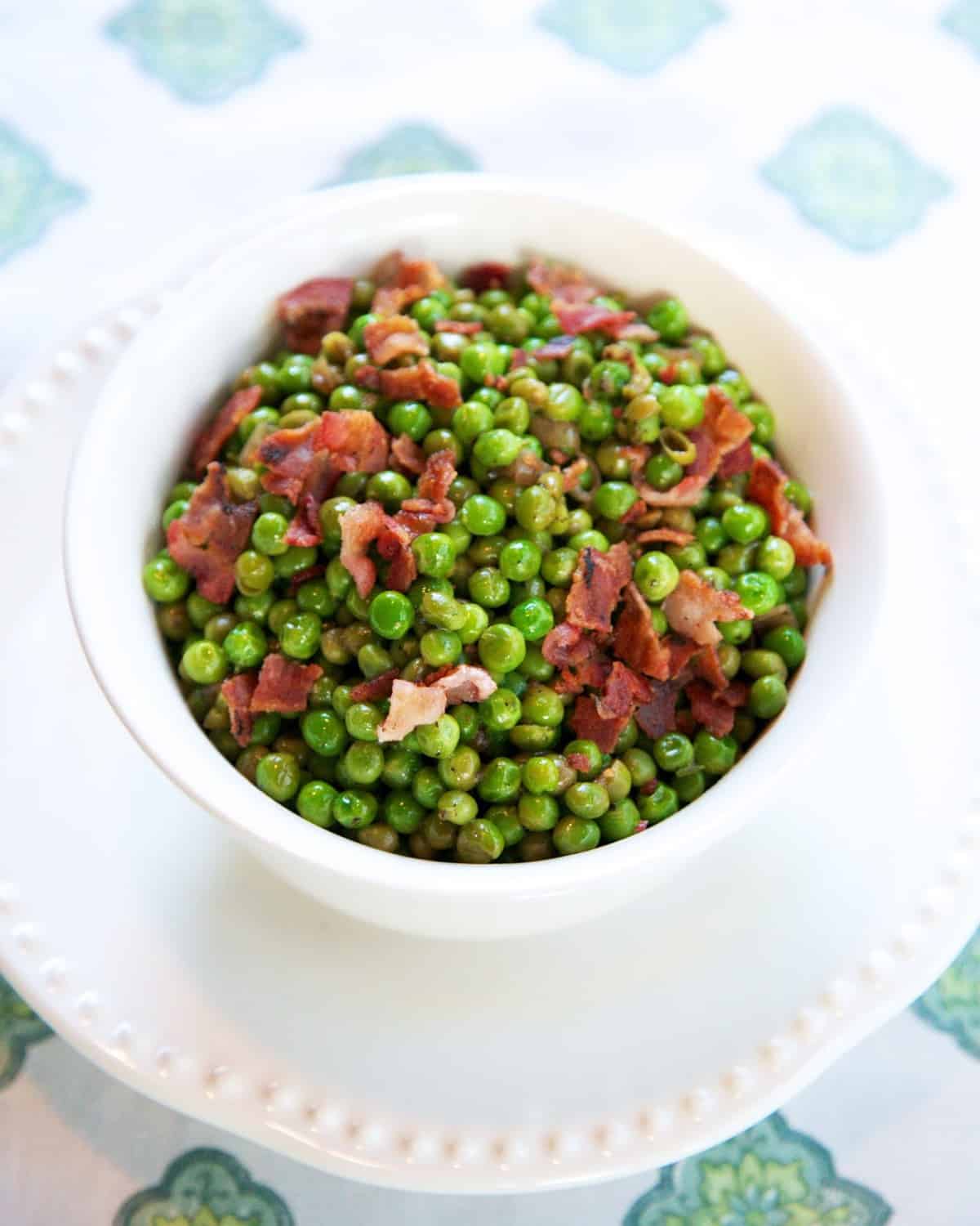 Green Peas with Crispy Bacon - jazz up frozen peas with orange juice, shallots and bacon. SO yummy! Ready in under 10 minutes!