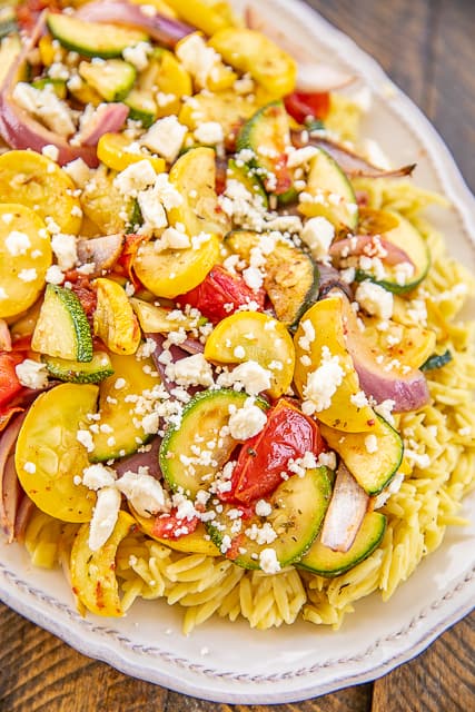 Grilled Vegetable Orzo Salad - so much amazing flavor! A great side dish or meatless main dish. Orzo, chicken broth, rosemary, olive oil, red onion, squash, zucchini, roma tomatoes, tossed in cider vinegar, olive oil, parsley, thyme, rosemary, salt and feta. Comes together in under 30 minutes. Can mix up the vegetables to your favorites. Good eaten warm or cold. YUM! #grilling #vegetables #grill #sidedish #meatlessmaindish