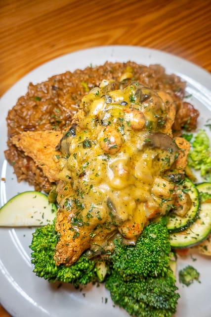 Chicken Pontchartrain from FloraBama Yacht Club - Pan sauteed chicken served with creamy cajun dirty rice and seasonal vegetables topped with a crawfish julie cream sauce