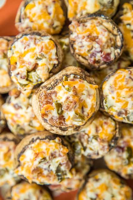 Jalapeno Popper Mushrooms - always the first thing to go at parties! Mushrooms stuffed with cream cheese, garlic, cheddar cheese, bacon and jalapeños. Seriously delicious! Can prep mushrooms ahead of time and refrigerate until ready to bake. Great for parties or a low-carb snack. #partyfood #mushrooms #jalapenopoppers