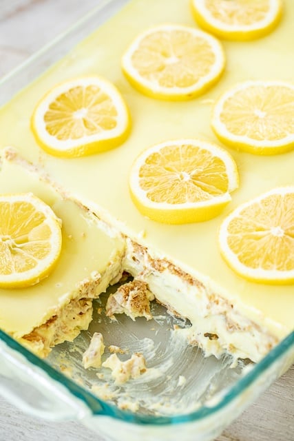 No-Bake Lemon Eclair Cake Recipe - lemon pudding, cool whip and  graham crackers layered and topped with lemon frosting. It gets better the longer it sits in the fridge - it is just SO hard to wait to eat it. SOOO good. People go nuts over this easy dessert recipe! Great for parties and potlucks. There are NEVER any leftovers! #nobakedessert #dessert #lemon #nobake