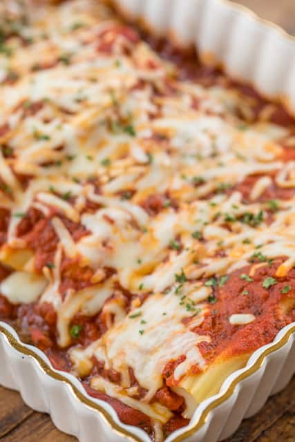 Easy Meat Lovers Manicotti Recipe - manicotti stuffed with cheese, ham and pepperoni and baked in a quick meat sauce. Super easy and DELICIOUS stuffed pasta casserole. Use string cheese to easily stuff cooked manicotti noodles. Can make ahead and refrigerate or freeze for later. All you need is a salad and some garlic bread for a quick weeknight meal!! #casserole #manicotti #pastacasserole #bakedpasta #freezermeal #makeaheadmeal