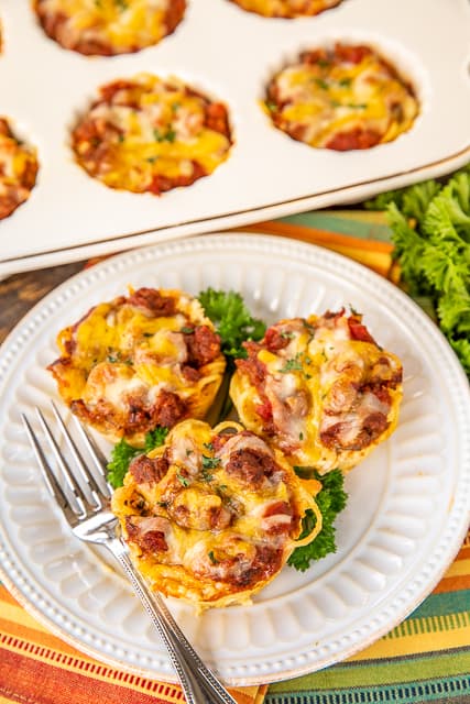 Mini Taco Spaghetti Pies - two favorites combined into one delicious dish!!! Bake in a muffin pan for a fun meal! Spaghetti, eggs, parmesan cheese, ground beef, taco seasoning, Rotel diced tomatoes and green chiles, spaghetti sauce, cottage cheese, butter, cheddar cheese. Can freeze leftovers for a quick meal later. Since they are small, they reheat in a flash! Our new favorite way to eat tacos and spaghetti! #tacos #spaghetti #freezermeal #recipe #spaghettipie #pasta