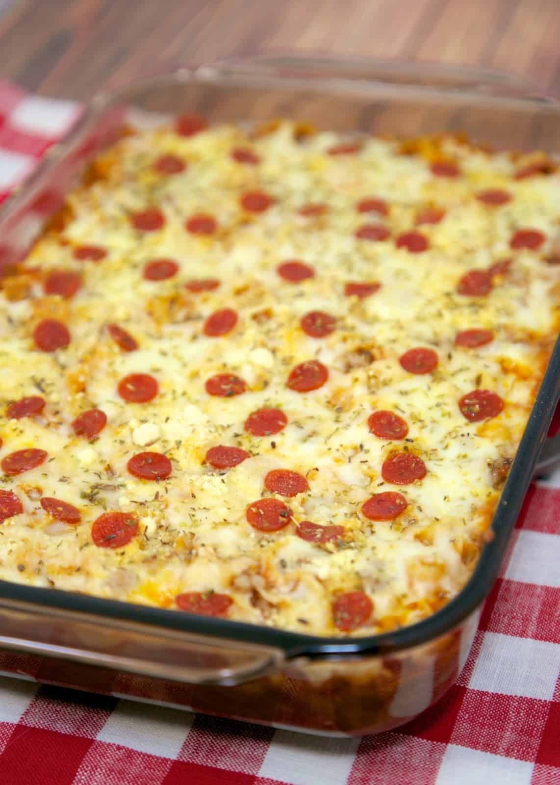 Pizza Pasta Bake - cheesy pasta bake with pizza sauce and your favorite pizza toppings! Hamburger or sausage, egg noodles, cheese soup, mozzarella cheese, parmesan cheese and pepperoni. Great weeknight meal! Kid-friendly and a good freezer meal! We love this easy pasta casserole recipe!