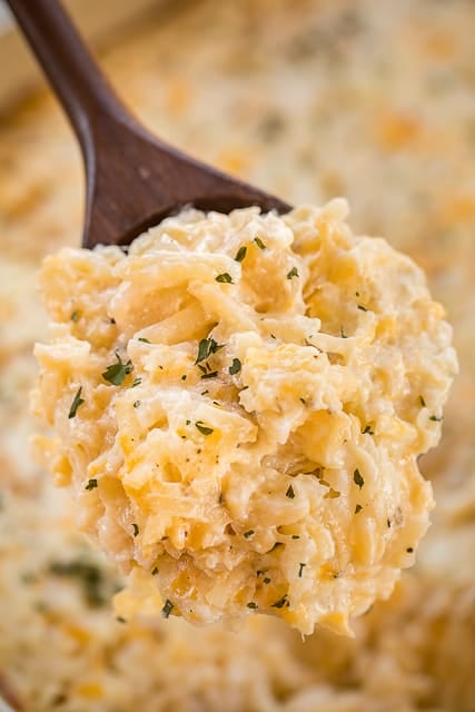 Cheesy Potato Casserole - dangerously delicious!!!! Loaded with three different types of cheeses - cheddar, parmesan and swiss. Can make ahead and freeze for later!! Hash browns, sour cream, Cream of Potato soup, garlic, pepper, cheddar, parmesan and swiss. Great for parties and potlucks. The most requested potato casserole in our house! #casserole #potatoes #freezermeal #sidedish #cheese