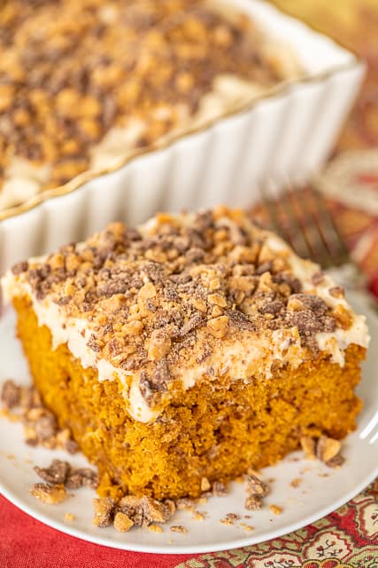 Pumpkin Spice Heath Bar Cake - OMG! This cake is to-die-for!!! Even pumpkin haters can't resist this delicious cake! Pumpkin Spice Toffee cake with homemade cream cheese frosting and topped with more toffee bits! YUM!!! Spice cake mix, pumpkin, pumpkin spice, sour cream, oil, eggs, milk, sugar, cream cheese, vanilla, butter, powdered sugar, toffee bits. Can make ahead of time and refrigerate until ready to serve. Great for potlucks and holiday meals! #pumpkin #dessert #cake #pumpkinspice #toffee