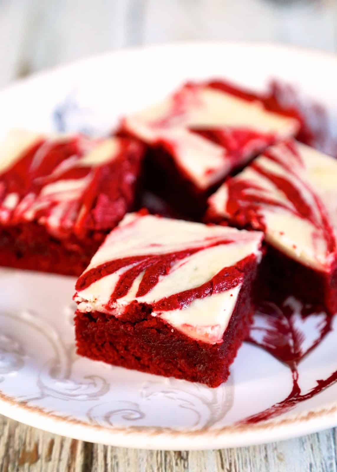 Red Velvet Cheesecake Brownies - homemade red velvet brownies with cheesecake swirled in the batter. All of my favorite desserts combined into one amazing recipe! These are SO good!!! Makes a great homemade gift.  Perfect ending to you holiday meal. We love this red velvet brownie recipe!