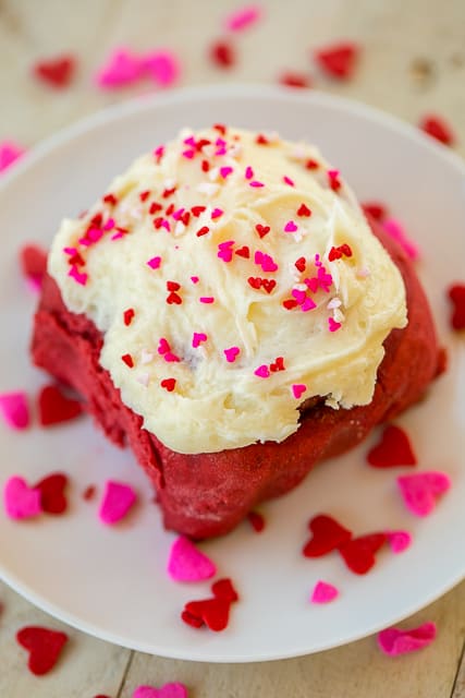 Red Velvet Cinnamon Rolls - TO-DIE-FOR delicious!!! SO easy! Start with a box of cake mix and add flour, water, and yeast. Bake and top with an amazing homemade cream cheese frosting! Makes 24 rolls. One pan for you and one for your Valentine! #redvelvet #valentinesday #cinnamonrolls