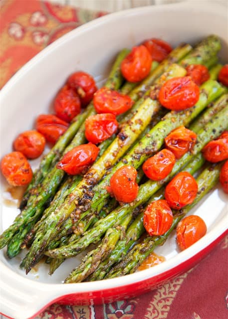 Roasted Asparagus and Tomatoes - takes one minute to toss together and is ready to eat in 15 minutes! SO quick and easy!! Asparagus,grape tomatoes, olive oil, balsamic, parmesan. Great weeknight side dish. Goes with everything! YUM!