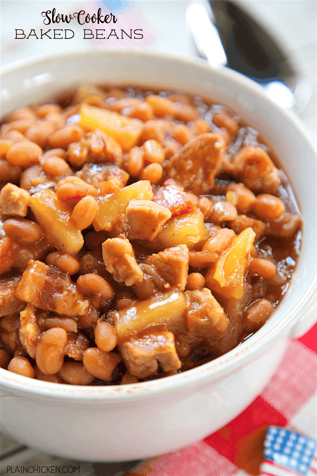 Slow Cooker Baked Beans - absolutely THE BEST baked beans! Bacon, baked beans, onion, mustard, bbq sauce, smoked pork and the secret ingredient - pineapple! SO good! I could make a meal out of these delicious beans! They slow cook all day in the slow cooker. Great for a potluck crowd. Took these to a cookout and everyone asked for the recipe!