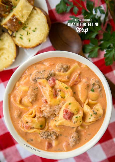 Slow Cooker Tomato Tortellini Soup - seriously delicious! Everyone LOVED this no-fuss soup recipe. Just dump everything in the slow cooker and let it work its magic. Serve soup with some crusty bread for an easy weeknight meal the  whole family will enjoy! Chicken broth, tomato soup, diced tomatoes, Italian sausage, chive and onion cream cheese and cheese tortellini combine to make THE BEST tomato soup EVER!