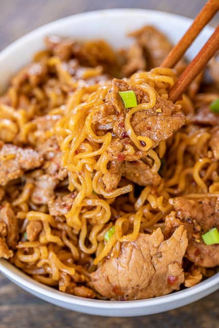 Spicy Pork Noodles - ready to eat in 10 minutes!!! Only 5 ingredients! Great weeknight meal!! Great way to use up leftover pork tenderloin. Pork tenderloin, brown sugar, soy sauce, chili garlic sauce, ramen noodles and green onions for garnish. Can add green beans or asparagus. We ate this twice in one week. Everyone LOVES this easy noodle bowl!! #pork #asian #ramen #noodles