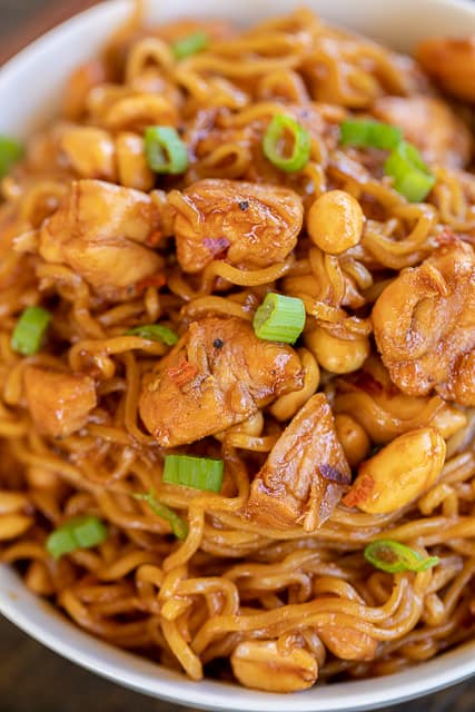 Spicy Sriracha Chicken Noodles - ready to eat in 15 minutes! No joke!!! SO easy!!! Only 6 ingredients - Chicken, ramen noodles, brown sugar, soy sauce, sriracha, and peanuts. Garnish with green onions. Great way to use up leftover chicken! Can add broccoli, green beans or asparagus. We ate this twice in one week. Everyone LOVES this easy noodle bowl!!
