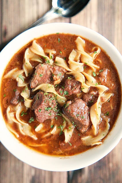 Slow Cooker Steak Soup - sirloin roast, beef broth, onion soup mix, tomato paste, Worcestershire sauce and egg noodles. Cooks all day in the crockpot - even the noodles. Serve with some crusty bread for an easy weeknight meal!