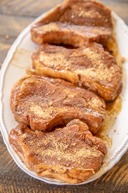 Steakhouse Pork Chops - hands down the BEST pork chops we've ever eaten!! Ridiculously easy to make! Marinate pork chops in steak seasoning and Worcestershire sauce then sprinkle with a delicious steakhouse rub of brown sugar, salt, garlic powder, onion powder, cumin, black pepper, cayenne pepper, and dry mustard. Ready to eat in under an hour! We made these twice in one week!! Our go-to pork chop recipe!