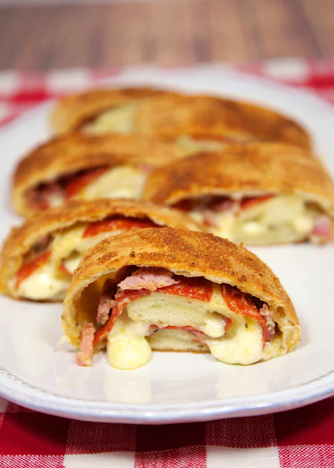 Garlic Butter Stromboli - pizza dough slathered with garlic butter and stuffed with pepperoni, ham and mozzarella. Serve with warm pizza sauce.