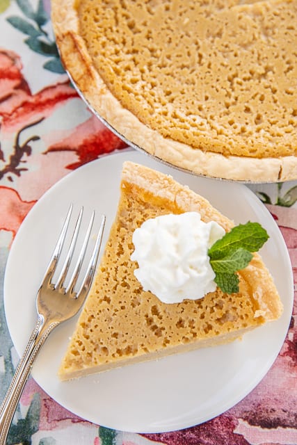 slice of pie on a plate topped with whipped cream and mint