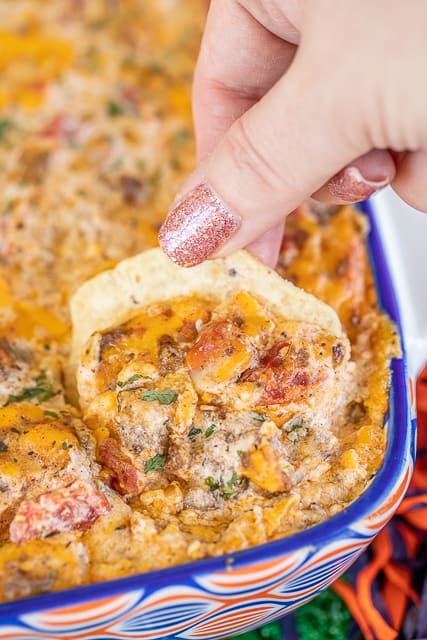 scooping taco dip from baking dish