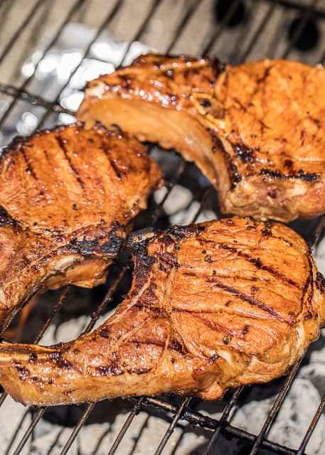 Zesty Grilled Pork Chops - better than any restaurant!!! Pork chops marinated in soy sauce, lemon juice, chili sauce, brown sugar and garlic. A little sweet and a little tangy. Perfect! Marinate overnight and grill for the perfect dinner! SO easy and everyone RAVES about these pork chops!!