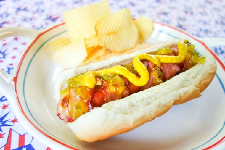hot dog with mustard on a plate