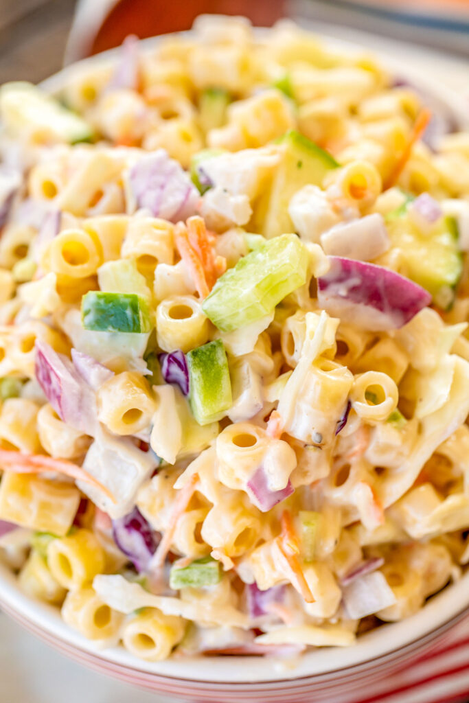 Macaroni Coleslaw - two favorites combined into one! Great make ahead side dish for potlucks and cookouts. Pasta, coleslaw mix, onion, celery, bell pepper, zucchini, water chestnuts, Miracle Whip, sugar, cider vinegar, salt and pepper. I never have any leftovers! SO good! #sidedish #potluck #pastasalad