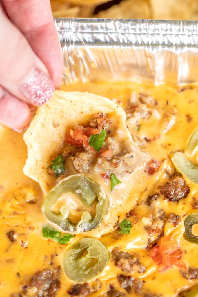 dipping chip in queso dip