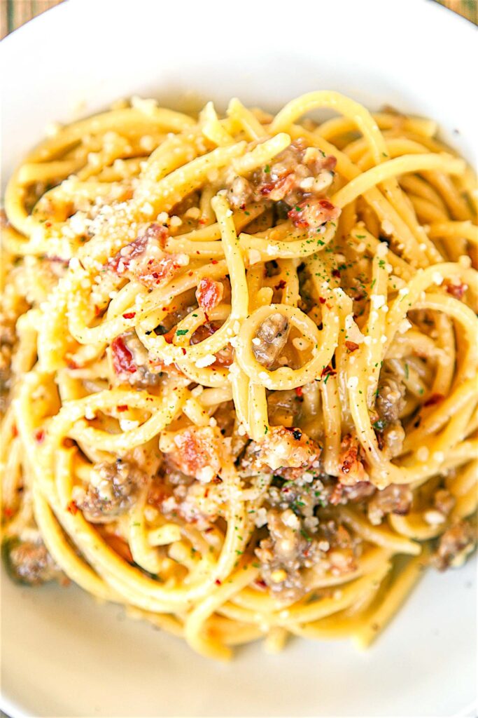 Bucatini Carbonara with Sausage - recipe from Buddy V's in Las Vegas. SO easy to make! Only takes about 10 minutes from start to finish! Bucatini, eggs, parmesan cheese, bacon, garlic, pepper and sausage. This was SO good that I wanted to lick the bowl! Easy enough for a weeknight.