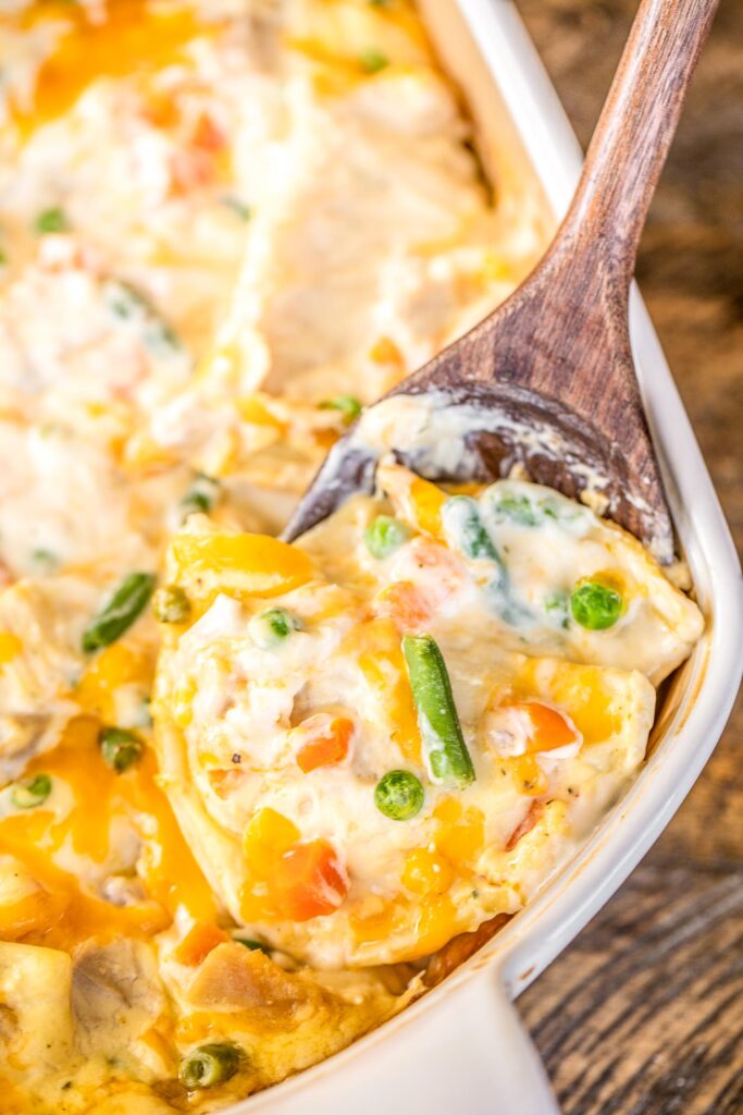 Chicken Pot Pie Pierogi Casserole - comfort food at its best! All you need is a few biscuits and dinner is done! Can make ahead of time and refrigerate or freeze for later. Pierogis, cream of chicken soup, sour cream, mixed vegetables, cheddar cheese, chicken, garlic, onion, salt and pepper. Everyone LOVES this easy casserole. Even our picky eaters cleaned their plate. #casserole #chicken #chickenpotpie