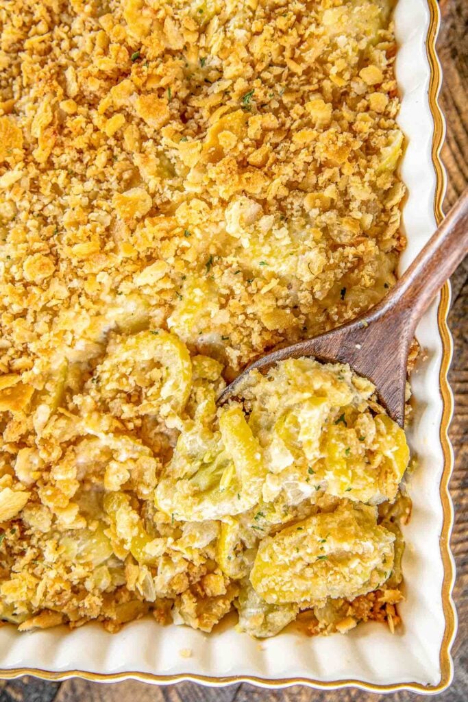 Old School Squash Casserole - a must for your holiday table!!! Loaded with 3 types of cheeses - cheddar, Swiss and parmesan. Seriously delicious! Squash, onion, butter, eggs, sour cream, mayonnaise, cheddar, swiss, thyme, salt, pepper, crushed Ritz crackers and parmesan. Can make ahead of time and refrigerate overnight. SO easy and SO delicious! Everyone LOVES this yummy side dish. #casserole #squash #sidedish #thanksgiving #christmas