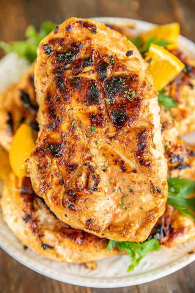 Orange Sriracha Grilled Chicken Recipe - chicken marinated in bbq sauce, mustard, Sriracha, honey and orange juice. Sweet, smokey and a tad bit spicy. SO good! Tons of great flavor and super juicy. We doubled the recipe for leftovers.