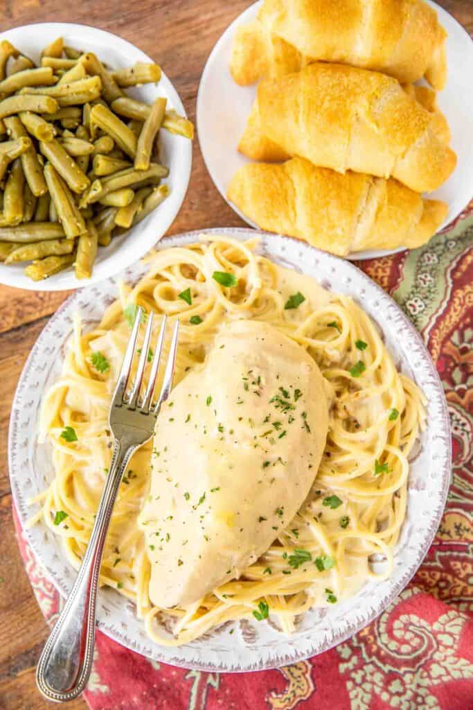 Slow Cooker Ranch Chicken - a weeknight family favorite!! Only 5 ingredients! Chicken, cream cheese, cream of chicken soup, chicken broth and ranch dressing mix. Serve over pasta, grits, rice or potatoes. Everyone cleaned their plate and asked for seconds! That never happens!!! This recipe is a keeper! #slowocoker #chicken #weeknightdinner