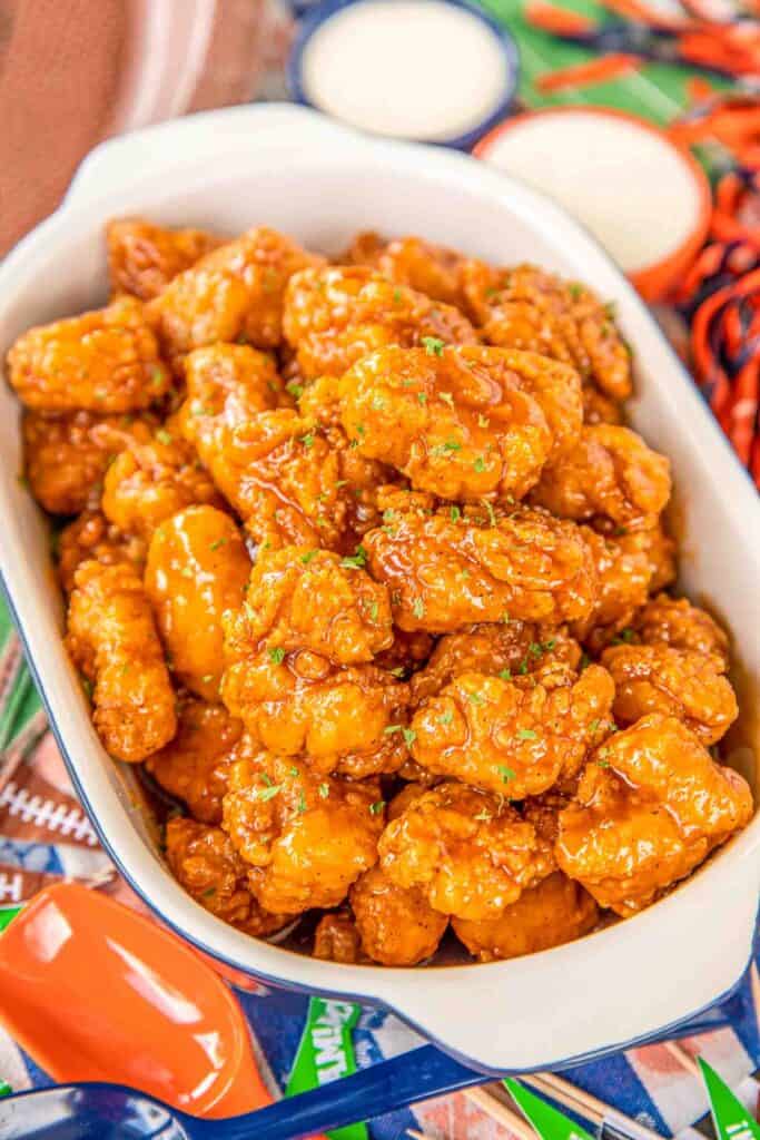 Sweet & Spicy Boneless Wings - great for parties or a quick lunch/dinner. Use frozen chicken bites and this comes together in no time!! Chicken tossed in hot sauce, brown sugar and butter. Seriously delicious!! Serve with fries and ranch or bleu cheese dressing. These are always the first thing to go at our football parties! #chicken #wings #tailgating #partyfood