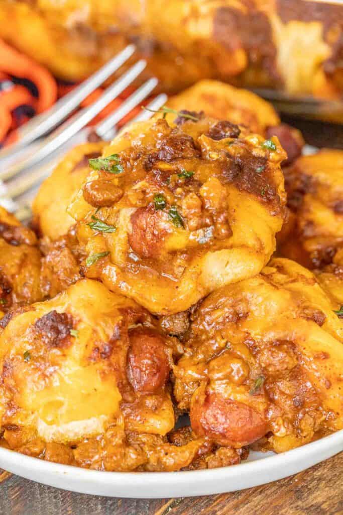plate of chili cheese smothered pigs in a blanket