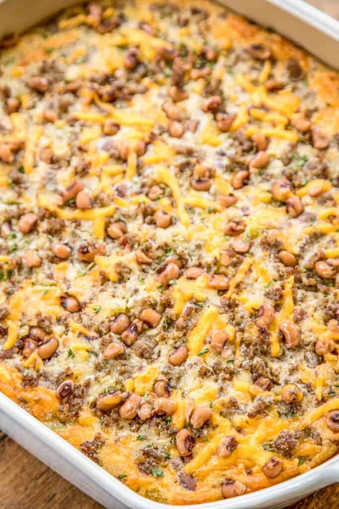 Black Eyed Pea Cornbread Casserole recipe - homemade cornbread loaded with sausage, creamed corn, cheddar cheese, black eyed peas, green chiles, and jalapeños. Perfect for your New Year's Day meal! Can make ahead of time and freeze for up to a month. Everyone LOVES this easy one pan meal! #casserole #cornbread #freezermeal