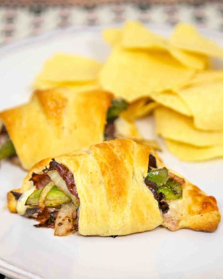 Philly Cheesesteak Crescents Recipe - deli roast beef, provolone, horseradish, onions and peppers wrapped in crescent rolls and baked - hot and ready in 15 minutes. A fun and quick lunch or dinner sandwich.